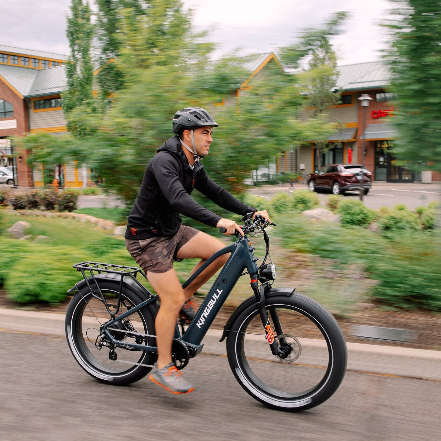 Man is riding a black commuter electric bike kingbull discover2.0.