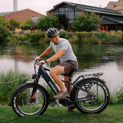 Man on the lawn with his electric bike.