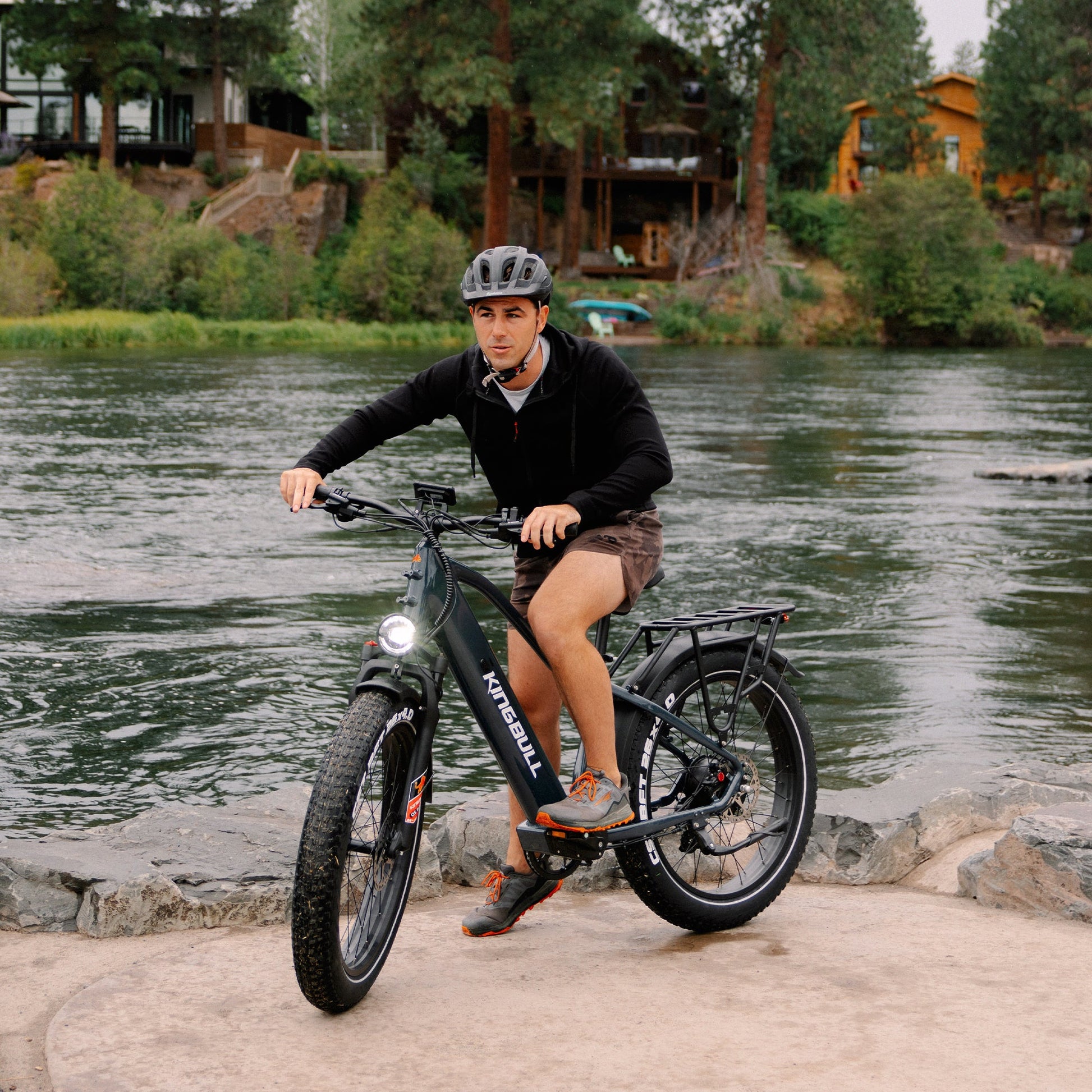 The man by the river is preparing to ride a commuter electric bike kingbull DISCOVER2.0.