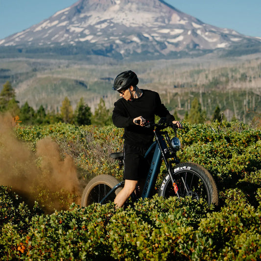 The man started the electric bicycle in a jungle, and the bicycle raised the sand